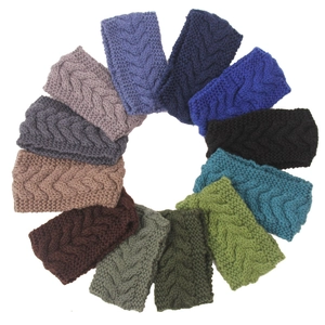Macro detail of various colorful cable knit headbands showcasing the thick wool texture