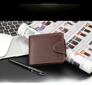Close-up of brown men's wallet with buckle closure and Baellerry logo on office desk