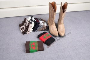 Close-up of knitted Christmas boot cuffs with reindeer pattern in various colors