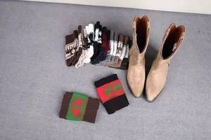Close-up of assorted Christmas knitted leg warmers with reindeer patterns and boots