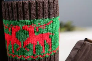 Detail of Christmas knitted leg warmers featuring red reindeer patterns and ribbed texture