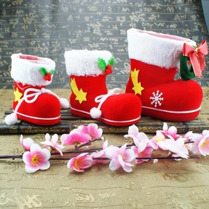 Three red flocked Christmas stocking candy bags with white plush cuffs in various sizes