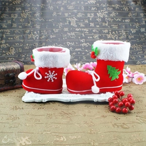 Detail of red flocked Christmas boots with snowflake embroidery and white faux fur trim