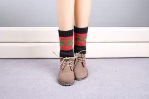 Detail of Christmas reindeer knit leg warmers in black with festive pattern over boots