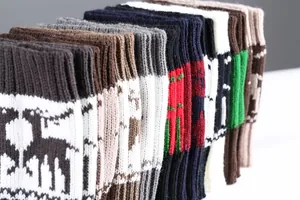 Close-up of knit Christmas leg warmers featuring reindeer and snowflake patterns
