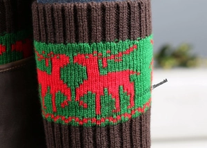 Detail of Christmas knitted boot cuffs with red reindeer jacquard on a brown background