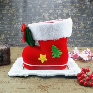 Close-up of red flocked Christmas boot with white fur trim and festive patches