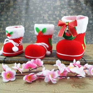Three sizes of red flocked Christmas boots with white trim and golden bell ornaments