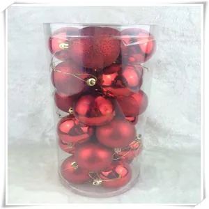 Detail of red Christmas baubles set in a clear cylinder with shiny and matte finishes