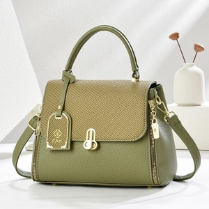 Detail of green litchi texture leather and yellow woven flap with gold hardware