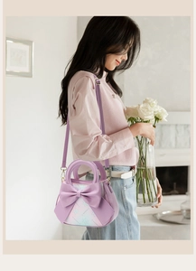 Detail of lavender handbag with large bow and floral pattern in a home setting