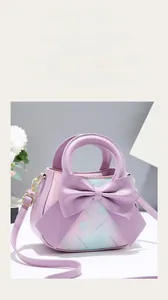 Close-up of lilac floral handbag featuring a large bow and elegant gold-tone hardware