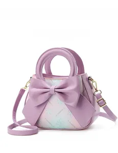 Detail of lavender purple handbag featuring a large leather bow and floral print base