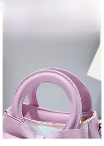 Detail of lilac purple handbag featuring thick rounded handle and premium stitching