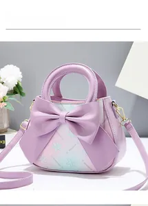 Detail of purple gradient PU leather handbag featuring a large bow and white floral prints