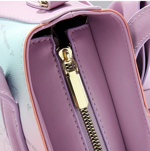 Detail of macaron pink and blue cross-grain leather bag with polished gold metal zipper