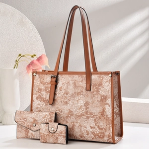 Three-piece floral jacquard handbag set including large tote and wallets on white surface
