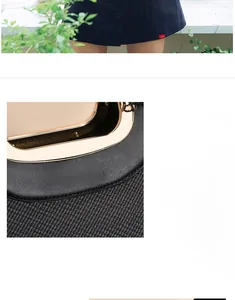 Detail of black leather and grey twill fabric with golden metal handle and brand logo