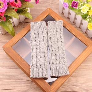 Close-up of light gray cable knit fingerless gloves with soft textured arm warmers