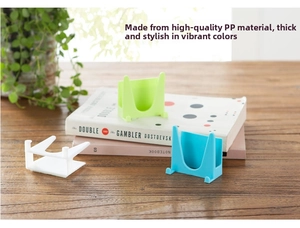 Dettaglio macro di supporti portaoggetti in plastica PP multicolore su tavolo in legno
