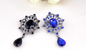 Detail of vintage hollow leaf brooches with sparkling waterdrop crystals in black and blue