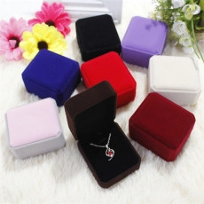 Flat lay of colorful velvet jewelry boxes for rings and pendants on white plush background
