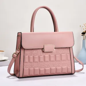 Close-up of pink leather handbag featuring gold clasp and square embossed texture