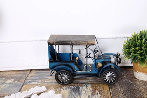 Détail d'une voiture miniature en métal bleu avec toit en bois et finitions vintage