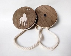 Detail showing wooden magnetic curtain tieback with white deer print and braided cotton rope