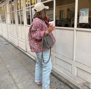 Détail de la veste matelassée rose à fleurs avec un jean décontracté bleu clair