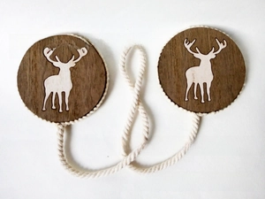 Detail of wooden reindeer curtain tiebacks with rustic round tags and white cotton rope