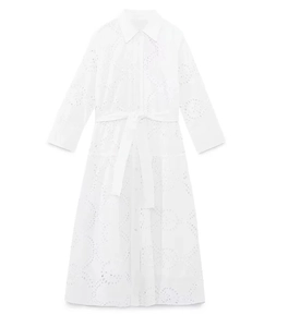 Detailed view of white midi dress featuring intricate eyelet embroidery and matching belt