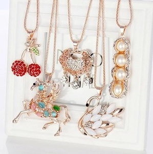 Detailed set of gold-plated necklaces with cherry, pegasus, swan and heart charms