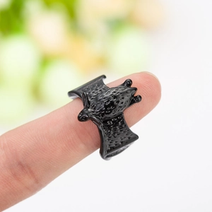 Gothic black bat open ring with textured wings shown on a finger in natural light