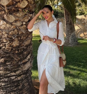 Detail of white eyelet embroidery cotton dress with waist belt and elegant shirt collar