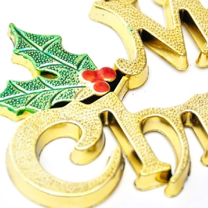 Macro detail of golden Merry Christmas hanging sign with holly leaves and red berries