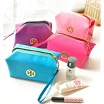 Detailed stack of multi-colored jacquard cosmetic bags with metallic logo and zipper
