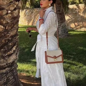 Women's white eyelet embroidery dress with long sleeves and brown shoulder bag