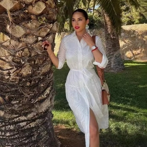 Elegant white eyelet embroidery shirt dress with collar and belt in outdoor sunny garden