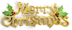 Detail of a gold Merry Christmas sign with green leaves and red berries for holiday decor