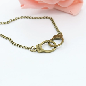 Detail of bronze handcuff pendant with FREEDOM engraving on vintage chain necklace