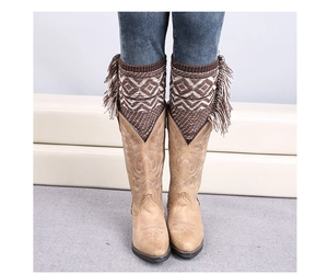 Detail of knit leg warmers with geometric patterns and long tassels on tan leather boots