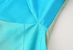 Close-up of vibrant blue and green gradient silk fabric showing fine stitching detail