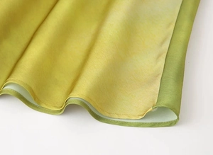 Close-up of vibrant gradient dress hem with professional stitching and silky fabric