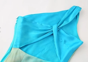 Close-up of smooth gradient satin dress with cross knot detail and hidden zipper