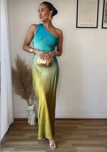 Detail of elegant one-shoulder gradient dress in silky blue and yellow satin fabric