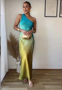 Detail of elegant one-shoulder gradient dress with silk-like satin finish and slim fit