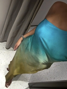 Detail of gradient satin maxi dress showing silky texture from blue to mustard yellow