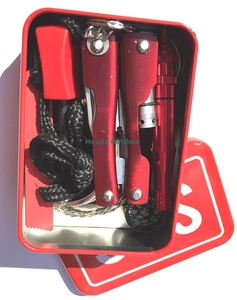 Outdoor survival kit in red metal case with multi-tool pliers, compass, and wire saw
