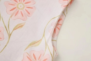 Détail macro du tissu à imprimé floral rose et coutures précises sur l'emmanchure